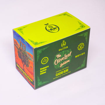 A rectangular product box for Olitia The Olive Leaf Herbisan Classic Olive, featuring a lime green top, dark green front panel with gold lettering, and a side panel with a red and blue scenic illustration.